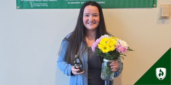 Hansey holds flowers and her award