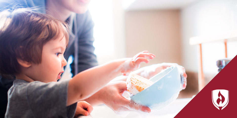 Kid washing dishes with parent