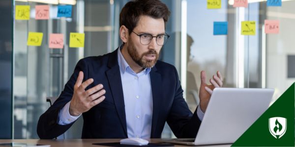 A frustrated manager gestures at his computer screen