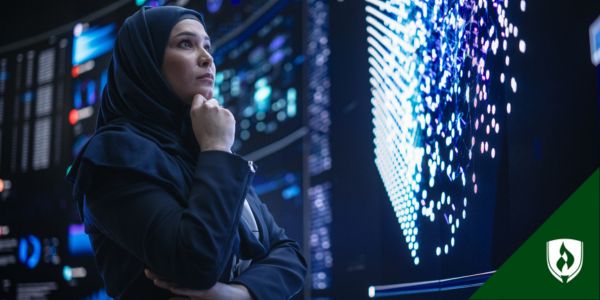 A project manager looks over multiple screens of information