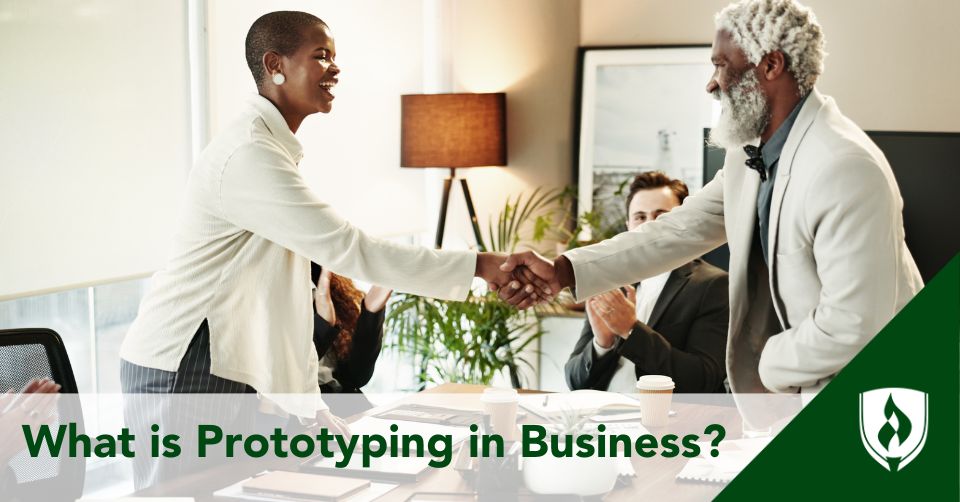 Two business people shake hands over a prototype