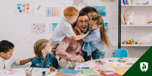 Children give a group hug to their preschool teacher