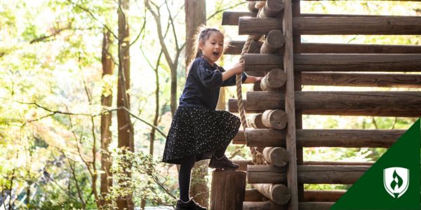 A child climbs up a log structure