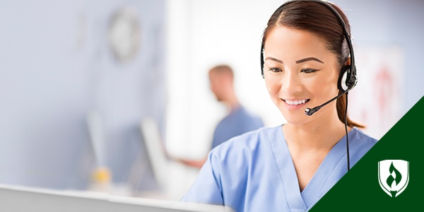 photo of a patient registrar working at a desk with a headset on