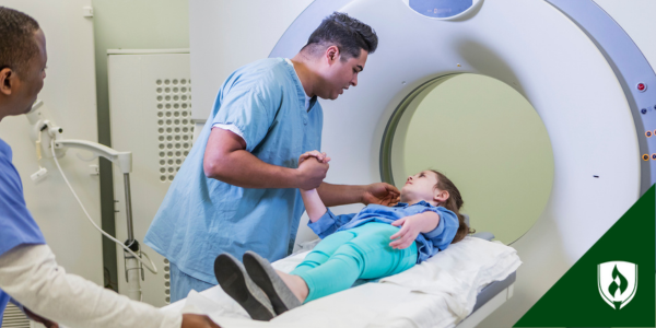 A radiologic technologist comforts a child as she is about to get her scan