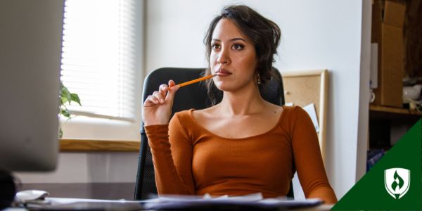 A medical biller looks at her computer in a bright office