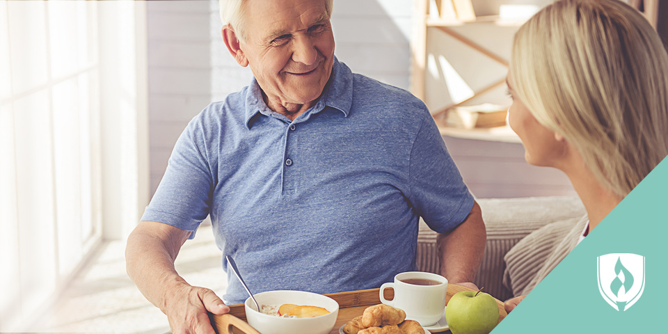 woman delivering food tray to smiling man