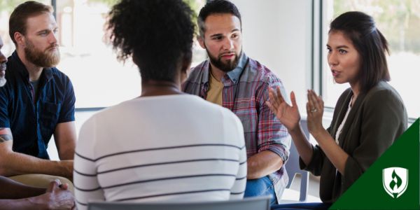 A human services assistant educates a group of people about symptoms
