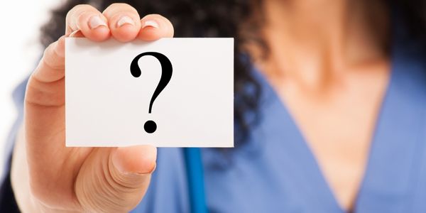 nurse holding up a card with a printed question mark