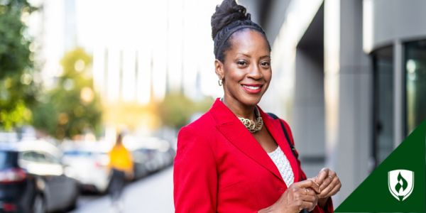A DNP nurse in a red blazer smiles outside her hospital
