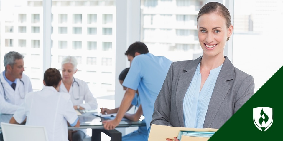 photo of a health information manager standing in a meeting of other healthcare professionals