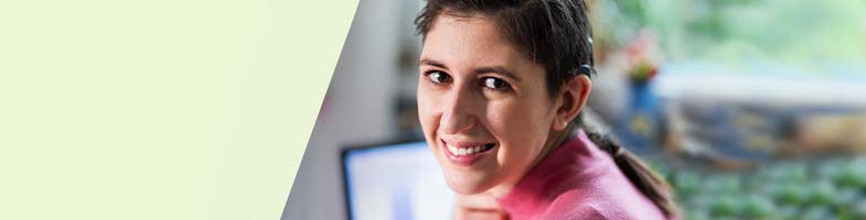 smiling hearing impaired woman with screen in background