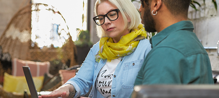 Male and female graphic design students on laptop tile image