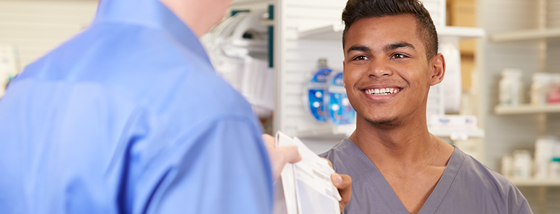 pharmacy tech giving a prescription to customer