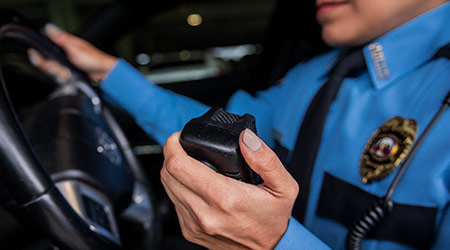 law enforcement officer in car using CB radio