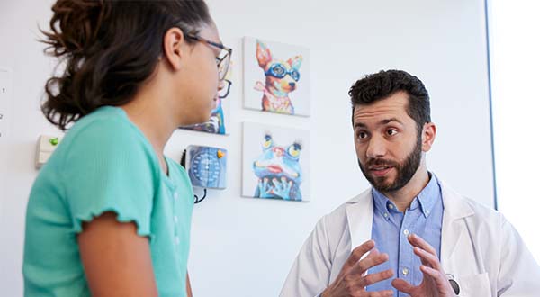 female nurse practitioner smiling at young girl